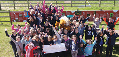 Group of people celebrating a fundraising event with a giant cheque 